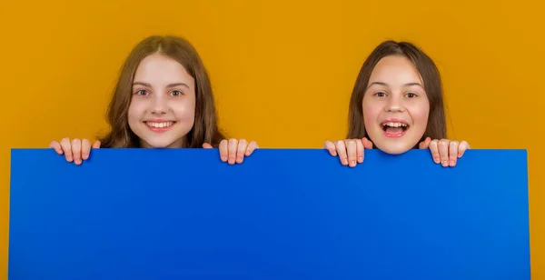 Счастливые Дети Пустой Голубой Бумагой Копировальным Местом Рекламы Желтом Фоне — стоковое фото