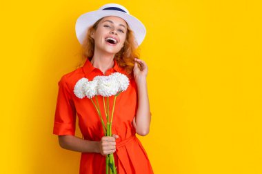 Anneler günü çiçekli kız sarıya izole edilmiş, kopyalama alanı. Stüdyoda anneler günü çiçekleri olan kız. Arka planda anneler günü çiçekleri olan kız. Anneler Günü 'nde kasımpatı çiçekli bir kızın fotoğrafı.