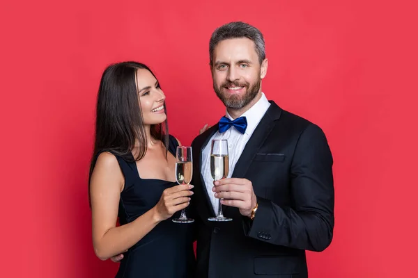 スタジオで歓呼とお祝いを 応援してお祝いするカップル シャンパンとお祝いするカップルの写真です 赤で隔絶された — ストック写真