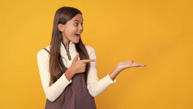 surprised girl with long hair on yellow background.