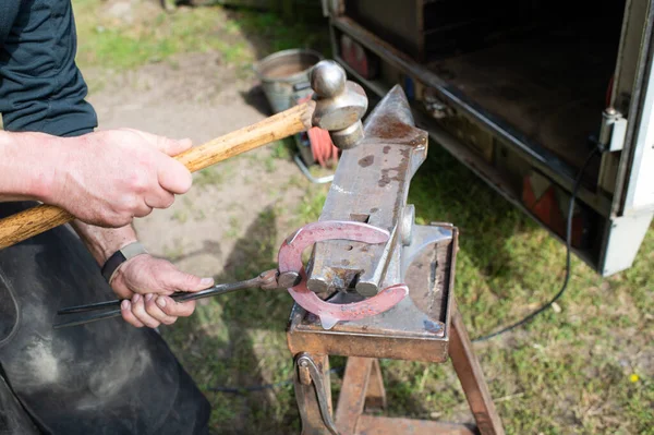 鍛冶屋の男の作物ビュー鍛造馬蹄形 ハンマーで金属アンビルを叩くことによって鍛冶屋鍛造馬蹄形 馬蹄形の鍛造 鍛冶屋 — ストック写真