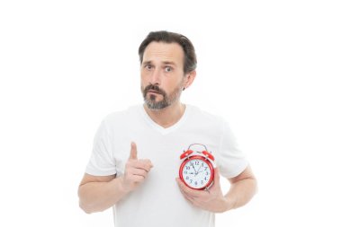 confused man with alarm clock isolated on white. man with alarm clock in studio. man with alarm clock on background. photo of man with alarm clock.