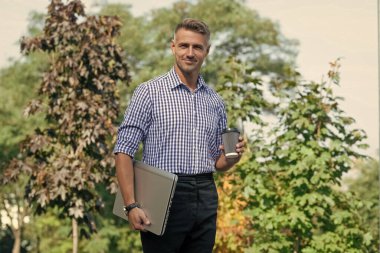 happy man with coffee. man freelancer drink coffee outdoor. business man has coffee break.
