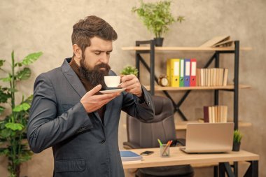 Ceketli, olgun girişimci sabah kahve molası vererek eğleniyor..