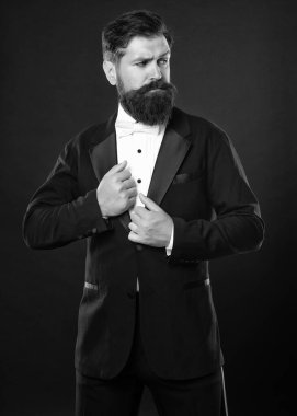 Siyah arka planda smokinli vahşi bir beyefendi, papyonlu..