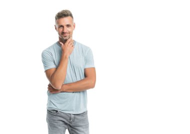 Saçları ağarmış gülümseyen olgun bir adam beyaz arka planda izole edilmiş kıllara dokunur..