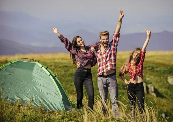 stock image Camping gear. Camping tent. Feel freedom. Happiness concept. Hiking activity. Friends set up tent on top mountain. Camping equipment. Weekend in mountains. Man and girls having fun in nature.