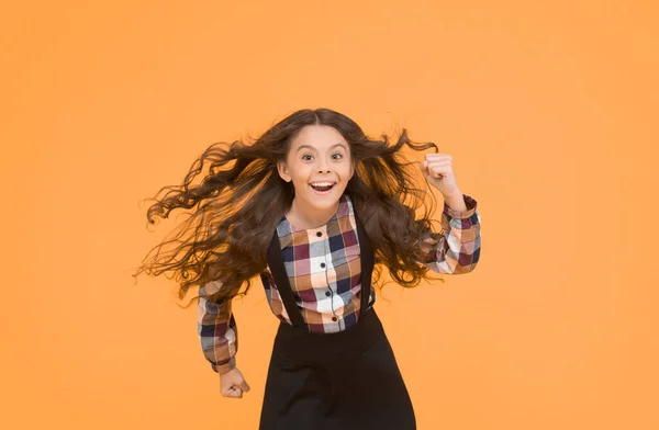 Air in her hair. natural beauty. Girl kid long hair flying in air. Child with natural beautiful healthy hair yellow background. Tips for healthy hair. Hairdresser salon. Beauty procedure. Extra light.