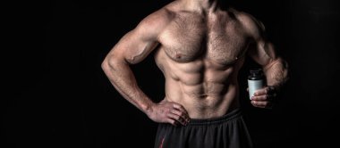 Steroidli kaslı vücut geliştirici, kopyalama alanı. Steroid kavanozlu kaslı vücut geliştirici. Steroid haplı kaslı vücut geliştiricinin fotoğrafı. Siyah steroidli kaslı vücut geliştirici..