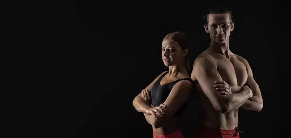 sport couple of fitness trainers in studio. advertisement banner with sport couple, copy space. sport couple isolated on black background. sport and fitness.