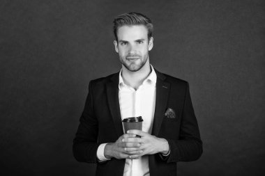 gülümseyen avukat sabah kahvesini siyah arka planda içer.