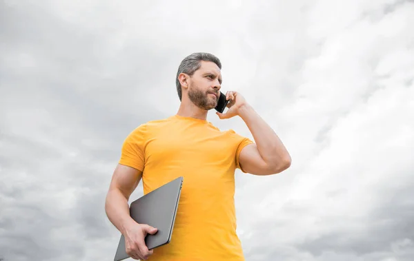 Homme Avec Ordinateur Portable Parlant Sur Téléphone Sur Fond Ciel — Photo