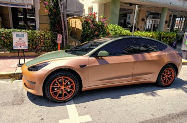 Miami Beach, Florida USA - 14 Nisan 2021: Tesla model turuncu mat 2019, yan görüş. elektrik geçişi.