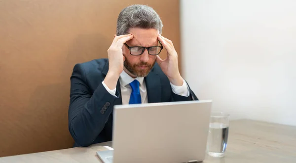 過労者のストレスは頭痛の種です 過労のビジネスマンの写真は頭痛がする 重労働のビジネスマンは事務所で頭痛がする 働き過ぎのビジネスマンは仕事中に頭痛がし — ストック写真