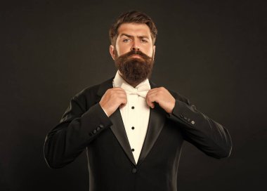 Smokinli sakallı damat siyah arka planda, papyonlu..