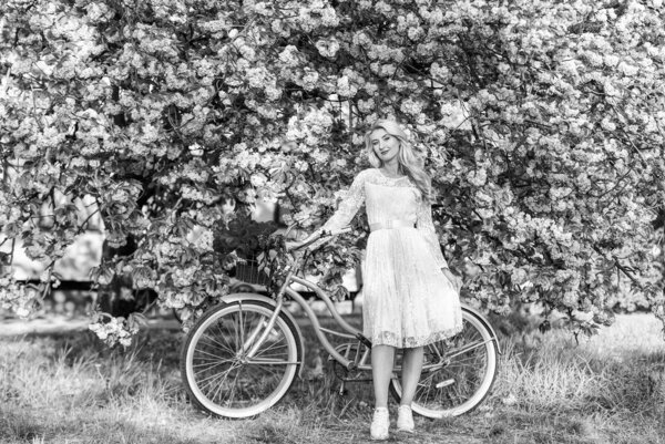 Seasonal allergy. Girl vintage cruiser bicycle near sakura tree. Woman in garden. Aroma concept. Sakura tree blooming. Sakura season. Tender fragrance. Hobby and leisure. Transportation and travel.