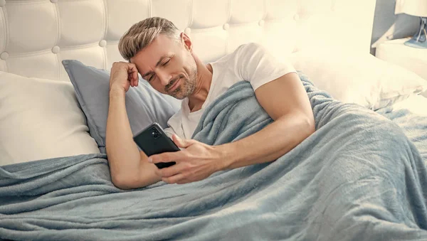 Cheerful Mature Man Bed Chatting Phone — 图库照片