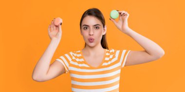 Sarı arka planda makaronu olan şaşkın, genç bir kız..