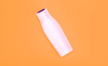 Sarı arka planda beyaz şampuan şişesi, cilt bakımı.