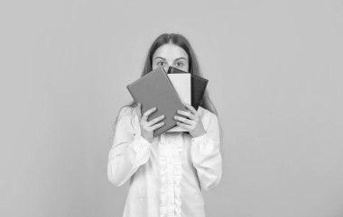 Bilgi günü. Çocuk defteri tut. Lise öğrencisiydim. Genç kız ödevlerini defterle yapıyor. Çalışma kitabıyla çalış. Kitabın arkasındaki çocuk. Okula dönüyorum. çocukluk eğitimi.