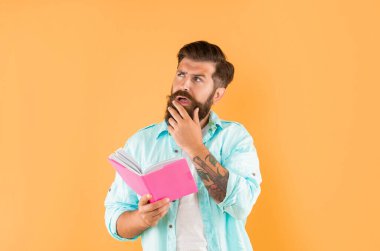 Sarı arka planda planlayıcısı olan düşünceli sakallı adam..