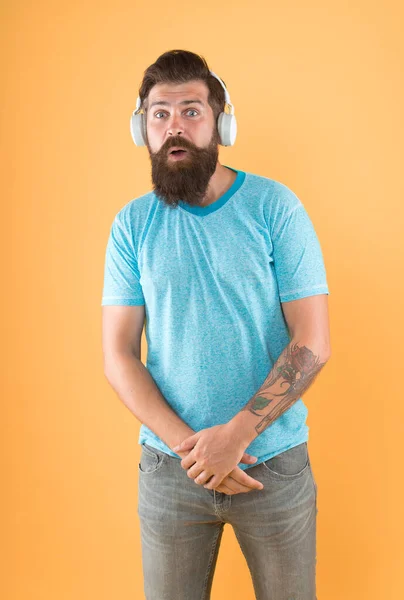 He has true ear for melody. Bearded man listen to music melody. Hipster wear earphones yellow background. Ring melody. Tune. Musical tone. Composition. Melody stuck in his head.