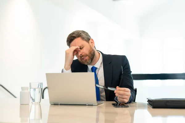 ストレスの多いビジネスマンのイメージは頭痛がする ストレスの多いビジネスマンはオフィスで頭痛がする ストレスの多いビジネスマンは仕事中頭痛がする ストレスのあるビジネスマンは頭痛がします — ストック写真