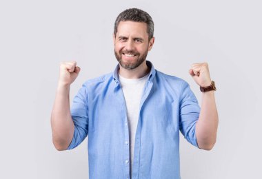 Gri arka planda izole edilmiş evet hareketiyle kazanan adam kazanır. Kazanan stüdyoda evet hareketiyle kazanır. Kazanan adamın fotoğrafı evet hareketiyle kazanır. Kazanan kazanır. Evet jest yapar. Gömlek giyer.