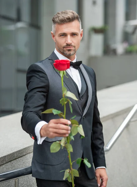穿着黑色燕尾服的优雅男子 在室外穿着燕尾服领带的男人 有玫瑰的燕尾服男 选择性重点 — 图库照片
