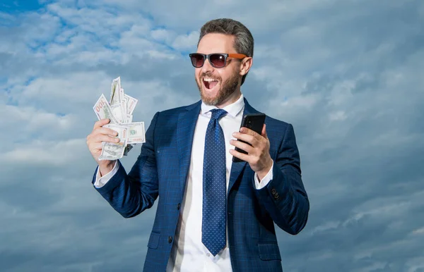 Stock image Successful man lawyer happy shouting with cash money and smartphone. Cash payment or smartphone payment. Cash purchase. Paying in cash for smartphone.