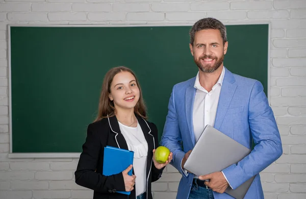 stock image cheerful girl with man teacher in classroom. education.