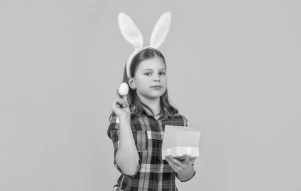 Tavşan Kulaklı Paskalya Çocuğu Sarı Arka Planda Kutu Yumurta Tutuyor — Stok fotoğraf