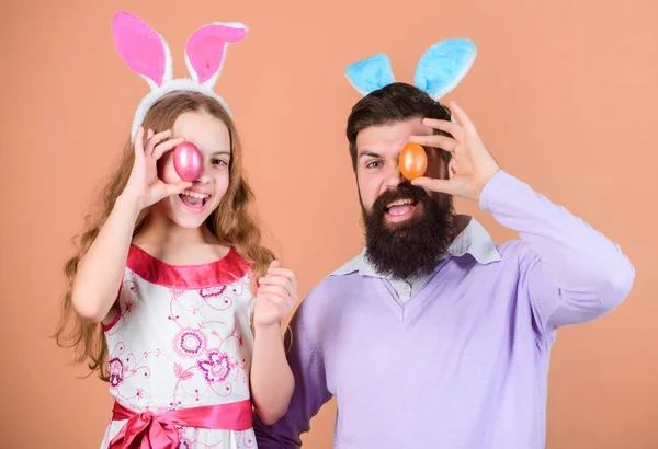 Look forward to celebrating Easter. Family celebration. Father and child with colored Easter eggs. Family of father and daughter in Easter bunny ears. Happy family. Family at annual Easter egg hunt.