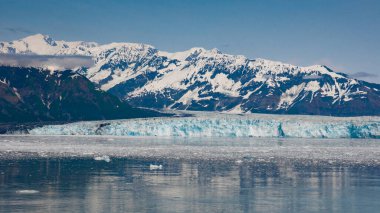 Karlı dağ kıyıları doğal manzara. Buzul Körfezi Doğası. Karlı dağ zirveleri. Hubbard Buzulu doğası Alaska, ABD. Dağ buzulu yavrusu ve deniz suyunda buz. Su manzarası..