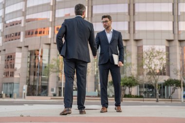 Takım elbiseli iki iş adamı el sıkışıyorlar. İki iş adamının el sıkışırken fotoğrafı. İki iş adamı el sıkışıyor. İki iş adamı el sıkışıyor..