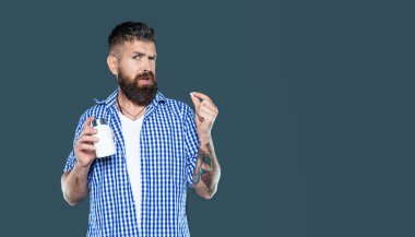 Gri arka planda vitamin hapı alan hoşnutsuz olgun bir adam..