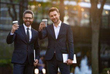 Yönetici dışarıda iş konuşuyor, fotokopi odası. Takım elbiseli bir yönetici kahve içerken iş konuşuyor. Yöneticinin kahve içerken çekilmiş bir fotoğrafı. Yönetici sokakta iş konuşuyor.