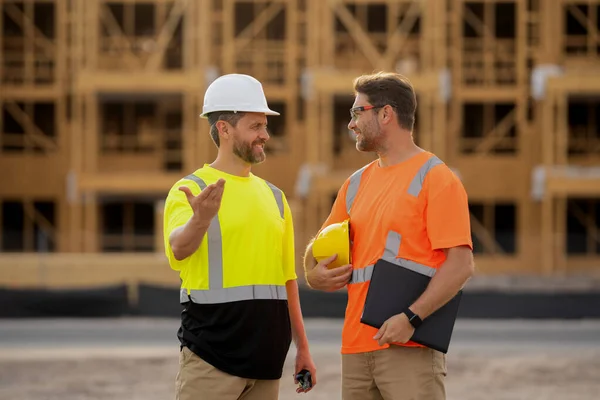 photo of architect men with construction project. architect men with construction project. architect men discussing construction project outdoor. architect men have construction project on clipboard.