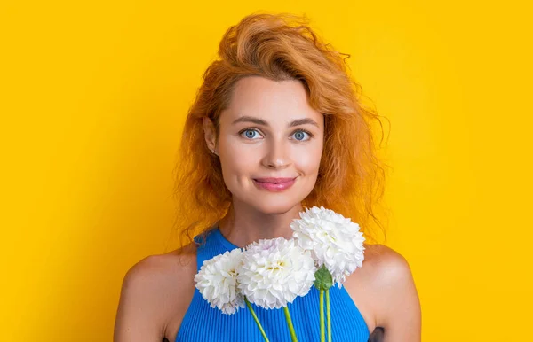 positive woman with spring flowers in studio. woman with spring flowers on background. photo of woman with spring flowers. woman with spring flowers isolated on yellow.