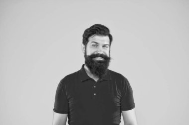 Sarı arka planda kendine güvenen ve yakışıklı sakallı bir adam. Saç ve sakal bakımı. Gülen erkek portresi. Sakallı, olgun bir hippi. Bıyıklı, vahşi beyaz adam..