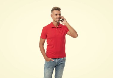 man in red tshirt speaking on cell phone isolated on white background.