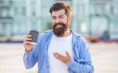 Sokakta kahve ikram eden, ürün sunan bir adam. Kahve ikram eden adamın fotoğrafı. Dışarıda kahve ikram eden bir adam. Dışarıda kahve ikram eden adam..