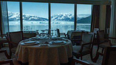 Doğal parktaki dağ buzulu boş bir restoran. Hubbard Buzul Restoranı. Seyahat güzergahı, insan yok. Manzaralı buzul körfezi doğasında panoramik pencereli boş restoran koltukları..