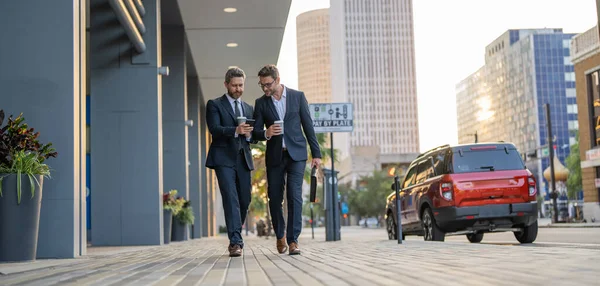 businessmen walk with phone in the street, copy space. businessmen walk with phone outdoor. businessmen walk with phone in suit. photo of businessmen walk with phone.