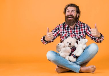 Hepsi senin için. Mutlu yüzlü adam yumuşak oyuncaklarla oynuyor. Çocuksu ruh hali konsepti. Erkekler sevgililer gününün tadını çıkarır. Gelmiş geçmiş en iyi hediye. Sevgililer günü hediyesi, sevgili için. Tatil kutlaması konsepti.