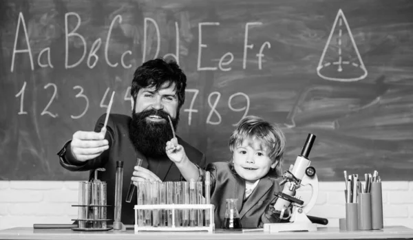 laboratory research and development. Chemistry beaker experiment. father and son child at school. bearded man teacher with little boy. Laboratory test tubes and flasks with colored liquids