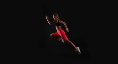 Stüdyoda kadın sporcu, dayanıklılık. Kadın sporcu arka planda. Spor kıyafetleri giyen kadın sporcunun fotoğrafı. Kadın sporcu siyah üzerine izole edilmiş..