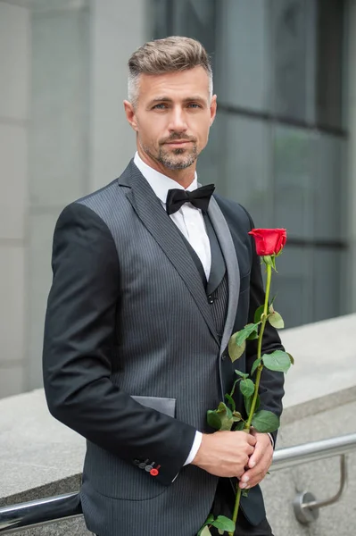 订婚的概念 浪漫的燕尾服男人庆祝订婚 带着玫瑰礼物订婚的男人 — 图库照片