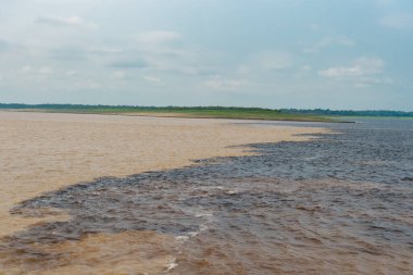 Nehir akışının doğal su manzarası. Seyahat yeri olarak doğa su manzarası. Amazon ve Rio Negro nehirlerinin doğal su manzarası. Doğanın sularla buluşan su manzarasının fotoğrafı..