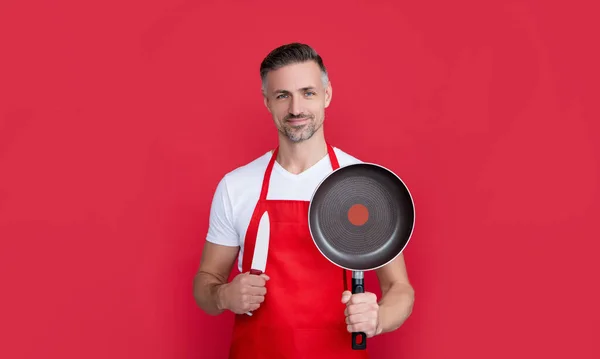 Positive Mature Man Chef Apron Frying Pan Knife Red Background — Stock Photo, Image